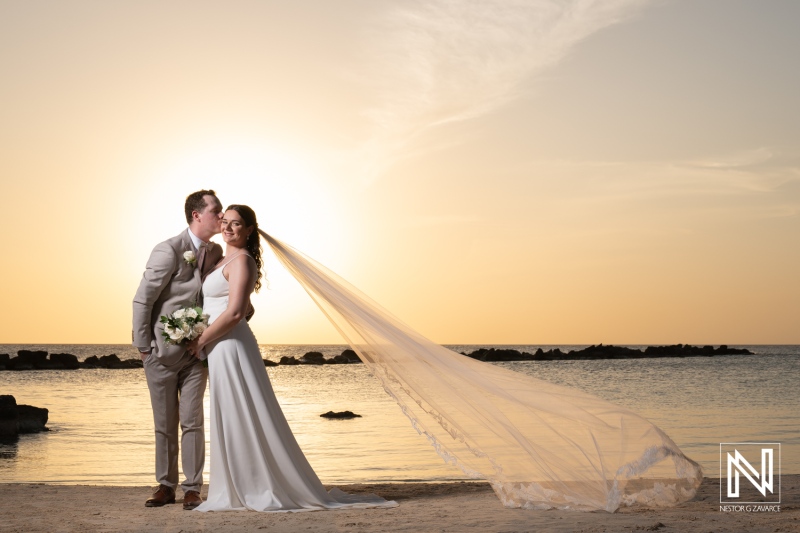 Couple celebrates wedding at Sunscape Curacao Resort during sunset with romantic beach backdrop and vibrant colors