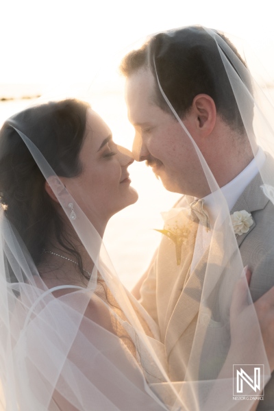 Couple shares an intimate moment during their wedding at Sunscape Curacao Resort, basking in the warm glow of sunset