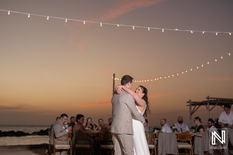 Couple shares a romantic dance during their wedding celebration at Sunscape Curacao Resort with a beautiful sunset backdrop