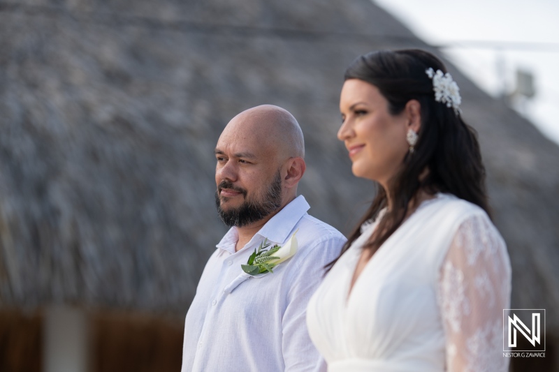 Couple exchanging vows during a romantic wedding ceremony at Mangrove Beach in Curacao, surrounded by lush tropical scenery