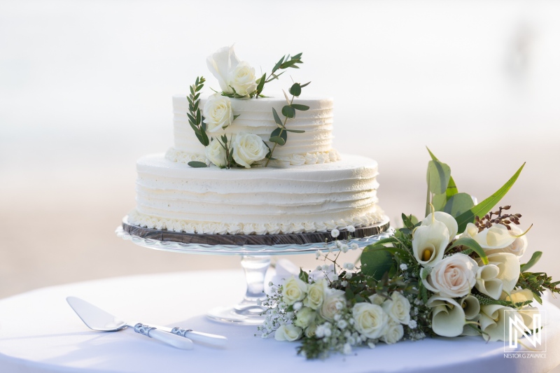 Wedding cake adorned with white roses at Mangrove Beach in Curacao during a beautiful wedding celebration