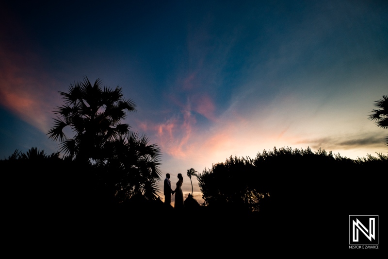 Wedding couple silhouetted against a vibrant sunset at Mangrove Beach in Curacao