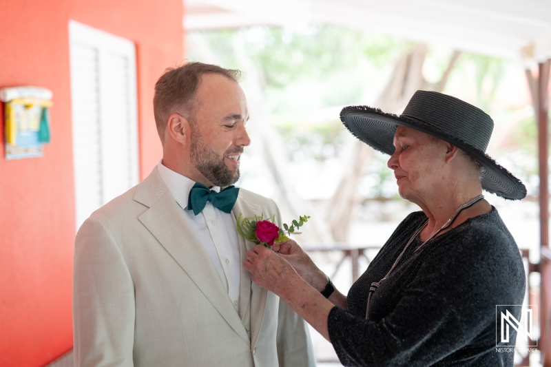 Couple prepares for wedding ceremony in Curacao with assistance from a family member