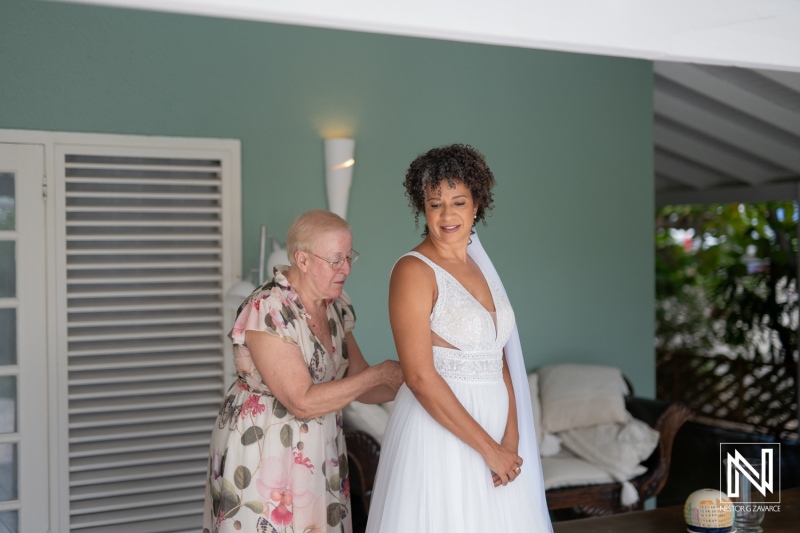 Bride prepares for wedding ceremony with assistance at location in Curacao during daytime