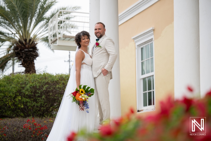 Couple celebrates wedding in Curacao with bright flowers and a sunny day on a lovely venue steps