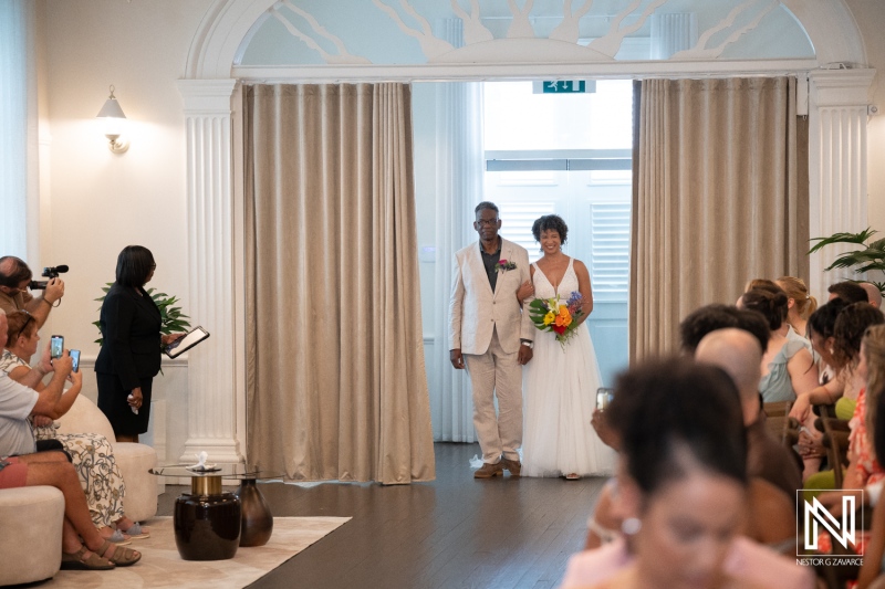 Couple walks down the aisle during their wedding ceremony in Curacao at a venue with guests in attendance