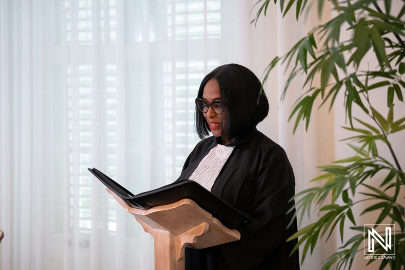 Wedding ceremony in Curacao takes place indoors with an officiant reading from a book