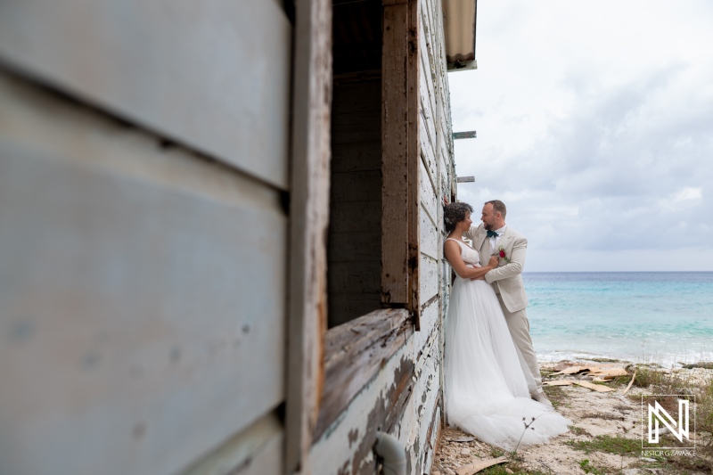 Couple shares a moment during their wedding ceremony in Curacao by the ocean under a cloudy sky