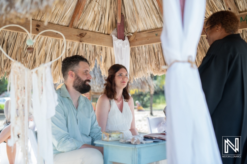 Bride and groom listening the officiant in wedding civil ceremony at the beach