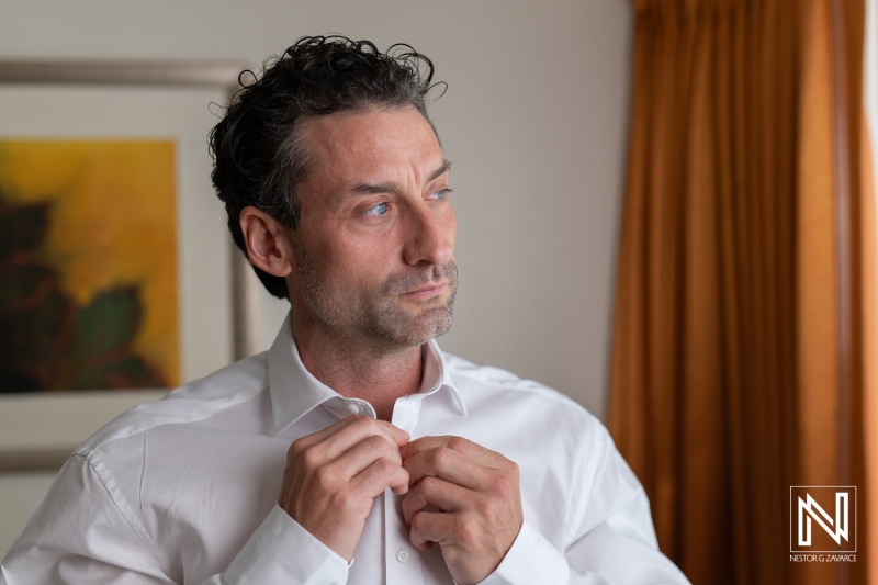 Groom preparing for wedding ceremony at Sunscape Curacao Resort with thoughtful expression and elegant attire