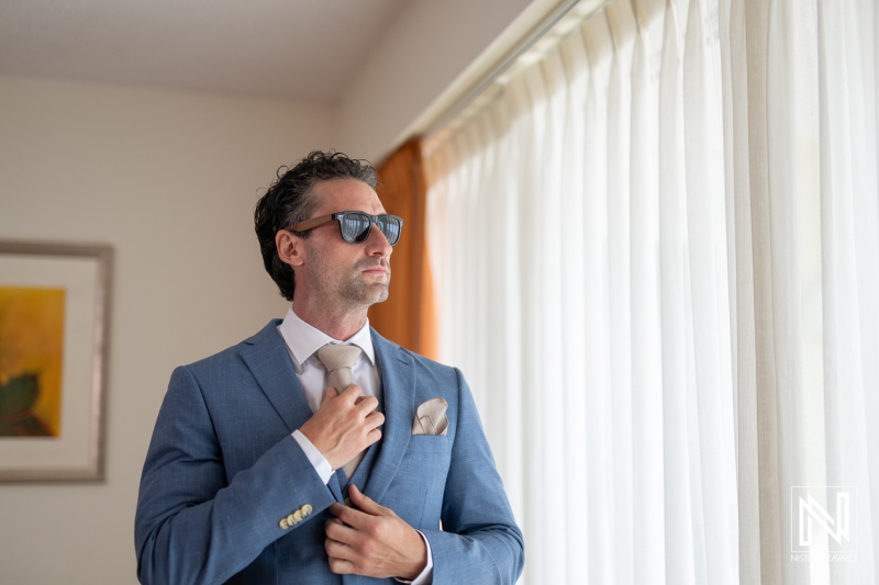 Groom preparing for wedding ceremony at Sunscape Curacao Resort with stylish sunglasses and tailored suit