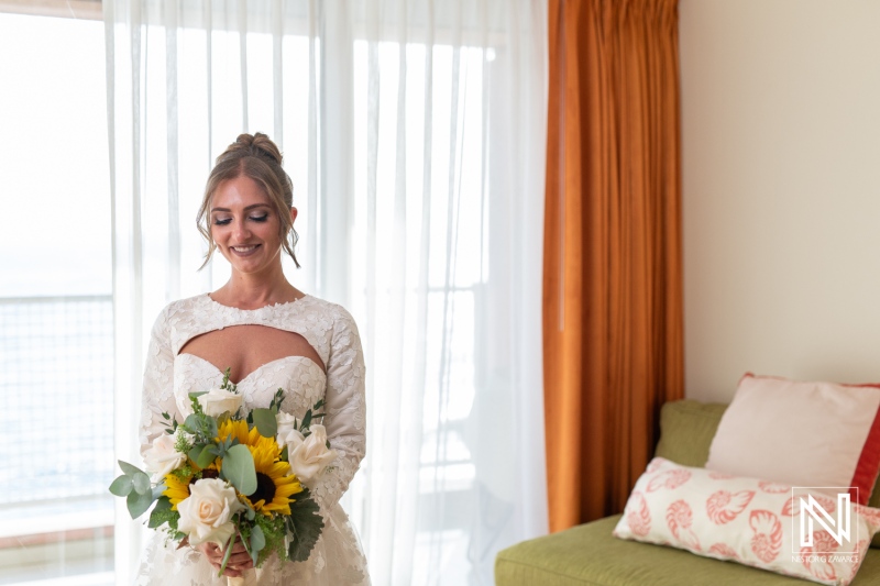 Beautiful bride holding a bouquet in a sun-drenched suite at Sunscape Curacao Resort before a wedding ceremony in Curacao