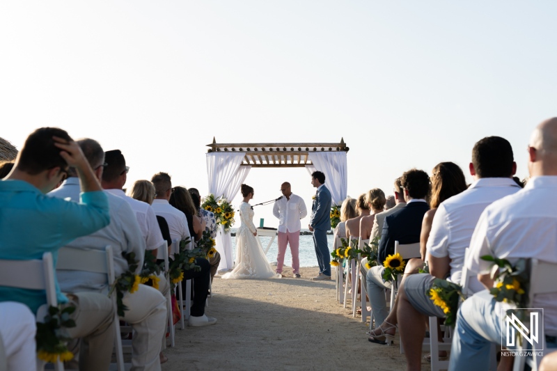 Wedding ceremony at Sunscape Curacao Resort with guests gathered by the beach under a beautiful sky