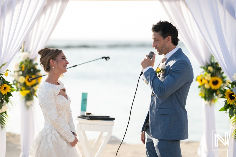 Couple exchanges vows at a romantic wedding ceremony on the beach at Sunscape Curacao Resort during sunset
