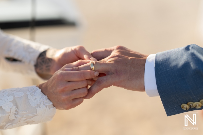 Wedding ceremony in Curacao at Sunscape Curacao Resort with a couple exchanging rings under the sun