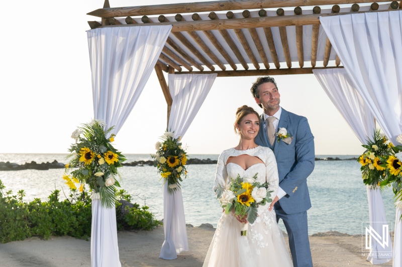 Couple celebrates wedding at Sunscape Curacao Resort with breathtaking ocean backdrop and vibrant floral decorations