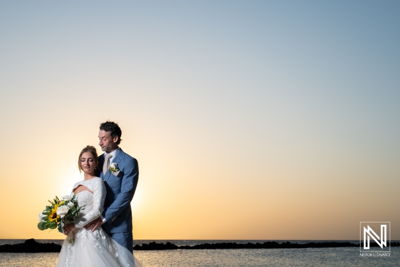 Couple celebrates their wedding at Sunscape Curacao Resort during a stunning sunset over the ocean