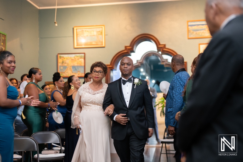 Wedding ceremony procession at the Curaçao Museum showcasing a beautiful couple and guests celebrating love in a vibrant setting