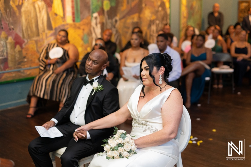 Wedding ceremony held at the Curaçao Museum featuring a couple exchanging vows amidst an intimate gathering of guests