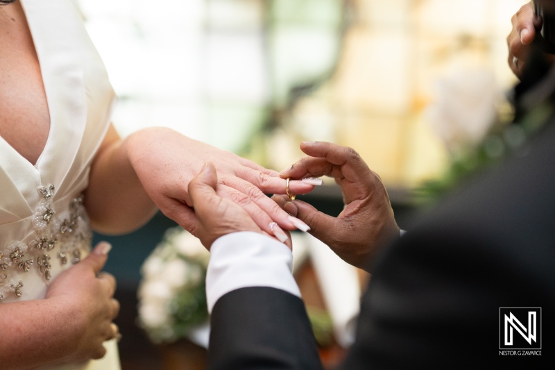 Wedding ceremony at the Curaçao Museum showcasing the exchanging of rings and love between the couple in a beautiful setting