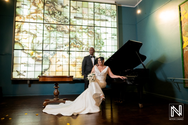 Couple celebrates their wedding at the Curaçao Museum with a beautiful piano backdrop and stunning stained glass window