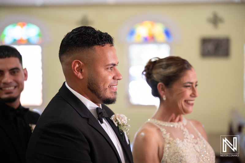 Couple exchanges vows during a wedding ceremony in Curacao surrounded by guests and family