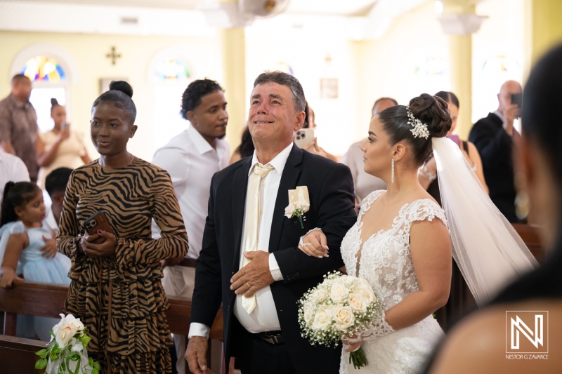 Wedding ceremony in Curacao with bride, her father, and guests in church setting