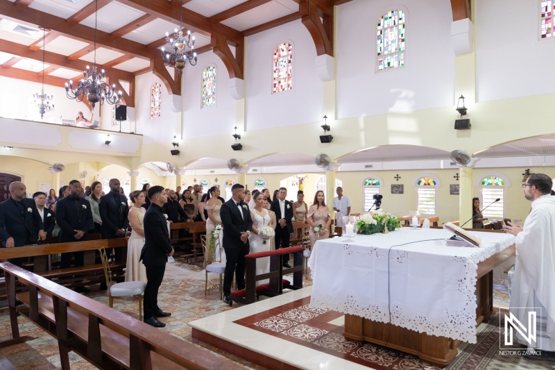 Wedding ceremony takes place in Curacao at a local church with guests seated and the couple standing at the altar