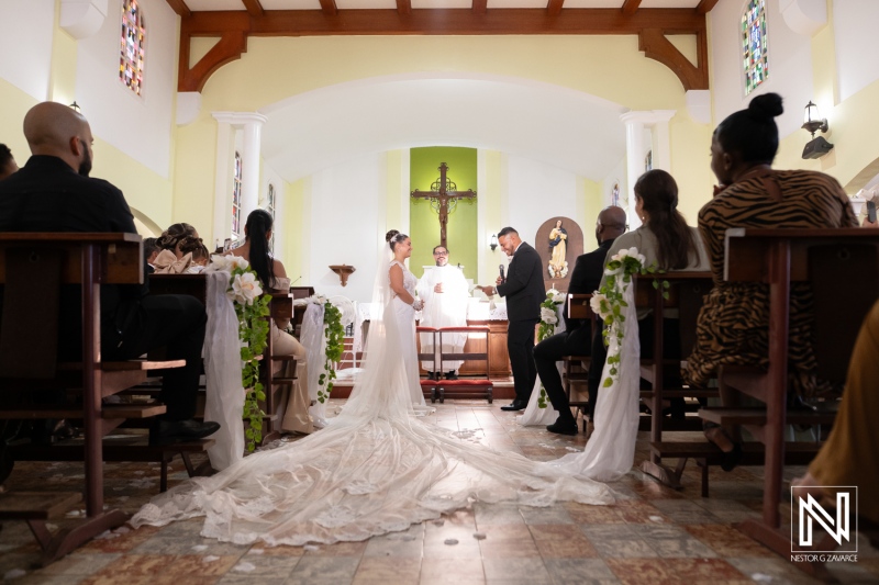 Wedding ceremony in Curacao takes place inside a church with guests present and the couple standing at the altar