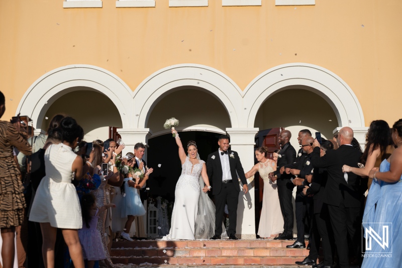 Couple celebrates their wedding in Curacao with family and friends outside a building on a sunny day