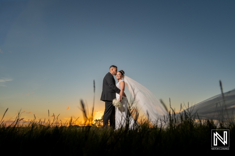 Couple enjoys a sunset wedding moment in Curacao with the sky filled with colors and a warm atmosphere around them