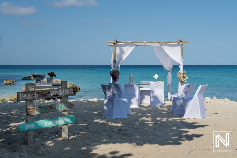 Beautiful beach wedding setup at Daaibooi Beach in Curacao featuring decorated table and chairs under a serene sky