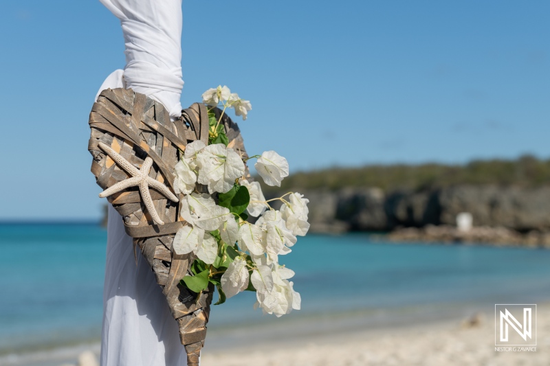 Wedding setup featuring a heart-shaped decoration with flowers and seashells at Daaibooi Beach in Curacao, perfect for a romantic ceremony