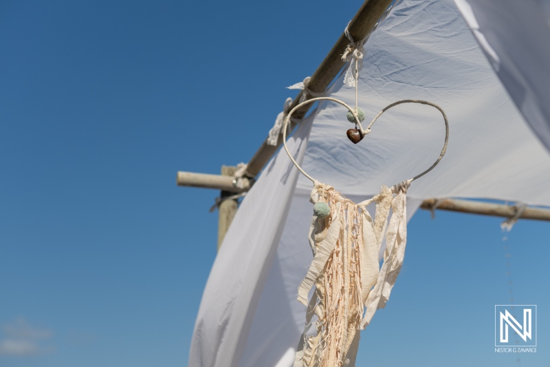 Decorative heart ornament hanging on a wedding arch at Daaibooi Beach in Curacao under a clear blue sky