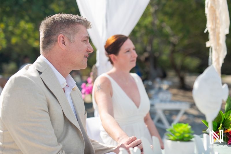 Couple celebrating their wedding ceremony at Daaibooi Beach in Curacao surrounded by nature and loved ones