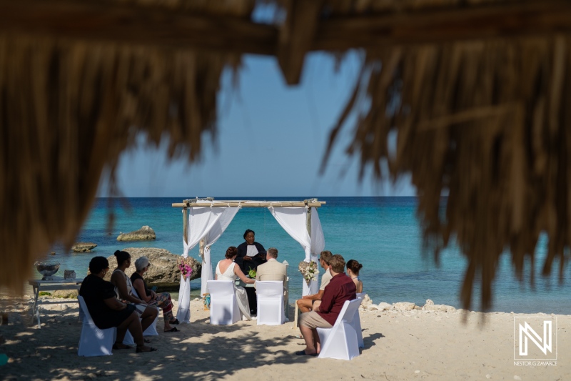 Ceremony held at Daaibooi Beach in Curacao with family and friends gathered to celebrate love on a sunny day