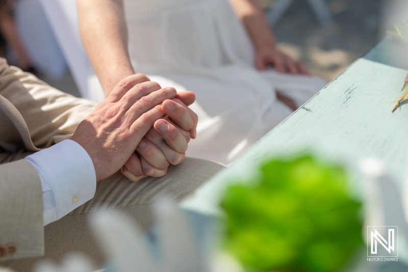 Couple's intimate moment during their wedding ceremony at Daaibooi Beach in Curacao, showcasing love and commitment under the sun