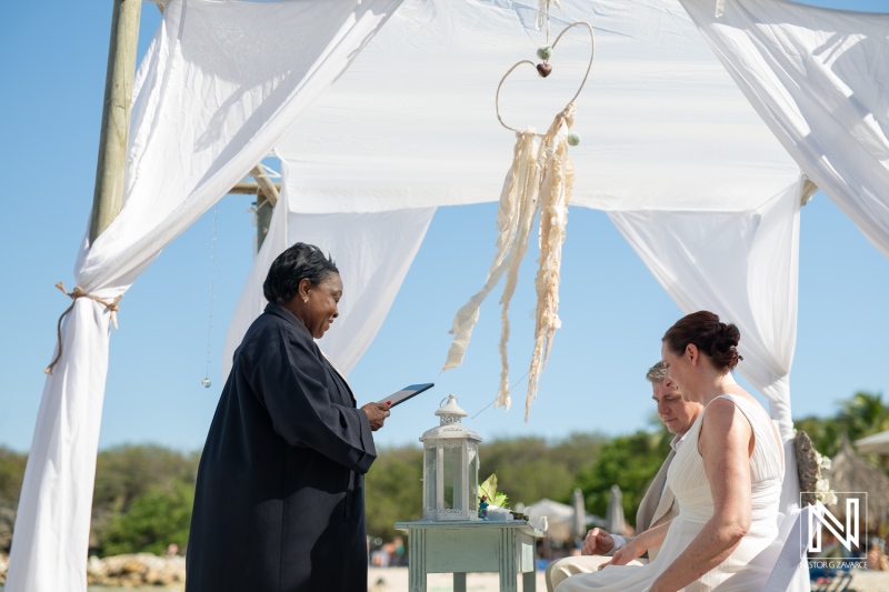 Wedding ceremony at Daaibooi Beach in Curacao under a beautiful canopy with an officiant and a couple exchanging vows