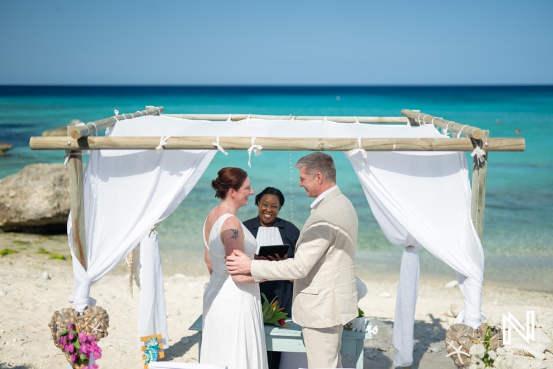 Wedding ceremony at Daaibooi Beach in Curacao surrounded by beautiful turquoise waters and a serene sky