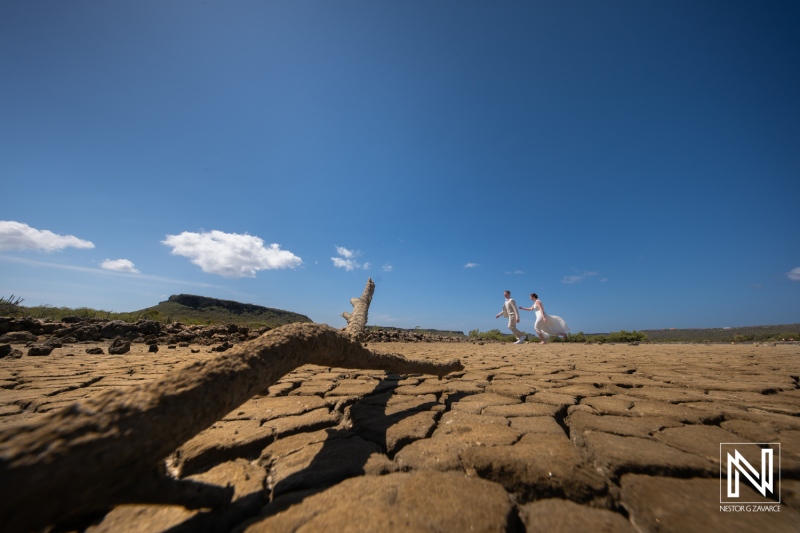 Couple celebrates wedding on dry landscape in Willibrordus, Curacao under blue sky with beautiful clouds