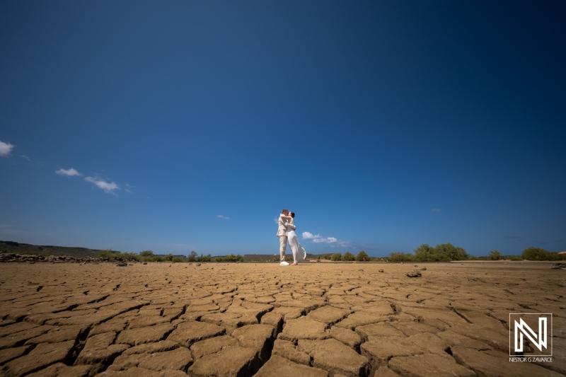 Couple celebrates their wedding on the cracked earth of Willibrordus, Curacao, surrounded by blue sky