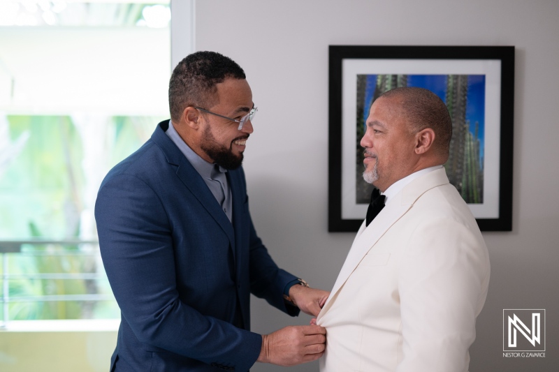 Two gentlemen preparing for a wedding ceremony at Avila Beach Hotel in Curacao, showcasing joyful moments of anticipation and friendship