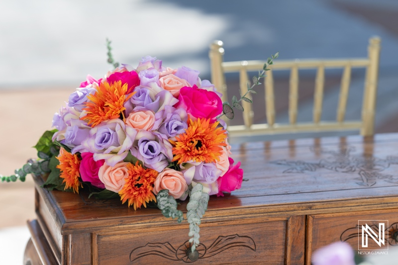 Beautiful bridal bouquet with vibrant flowers placed on a wooden table at Avila Beach Hotel in Curacao during a wedding ceremony