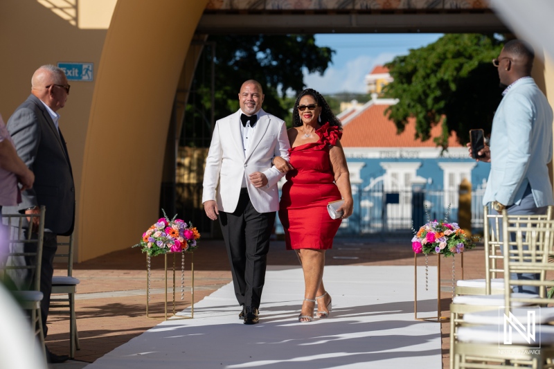 Elegant wedding ceremony at Avila Beach Hotel in Curacao featuring a couple walking down the aisle during a beautiful sunny day