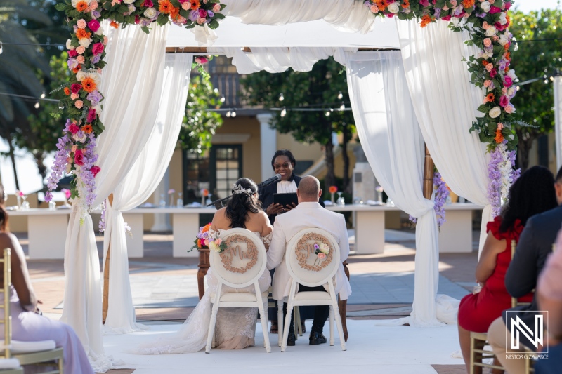 Beautiful wedding ceremony at Avila Beach Hotel in Curacao surrounded by vibrant flowers and joyful guests celebrating love