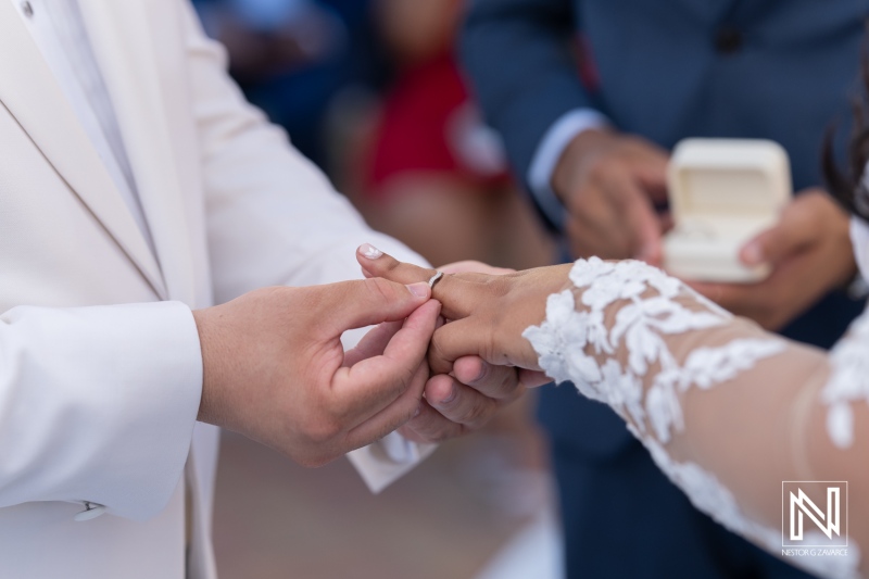 Couple exchanges wedding rings in a romantic ceremony at Avila Beach Hotel in Curacao, creating lasting memories on their special day