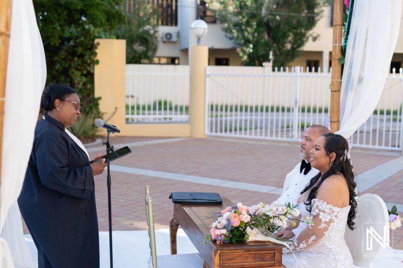 Wedding ceremony at Avila Beach Hotel in Curacao featuring a joyful couple and an officiant by the altar during a sunny day