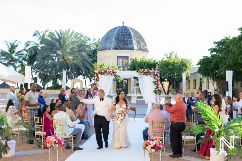 Beautiful wedding ceremony at Avila Beach Hotel in Curacao features stunning bride and groom surrounded by joyful guests celebrating love and unity