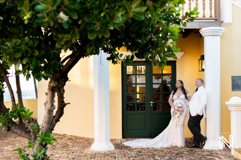 Couple enjoys romantic moment outside Avila Beach Hotel in Curacao during their wedding celebration surrounded by tropical scenery