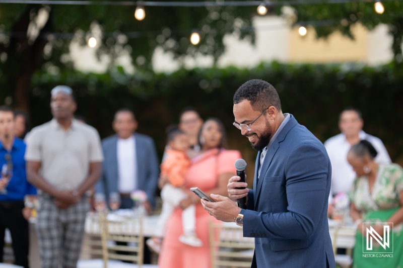 Celebration unfolds at Avila Beach Hotel in Curacao during a joyful wedding reception as guests gather and share heartfelt speeches
